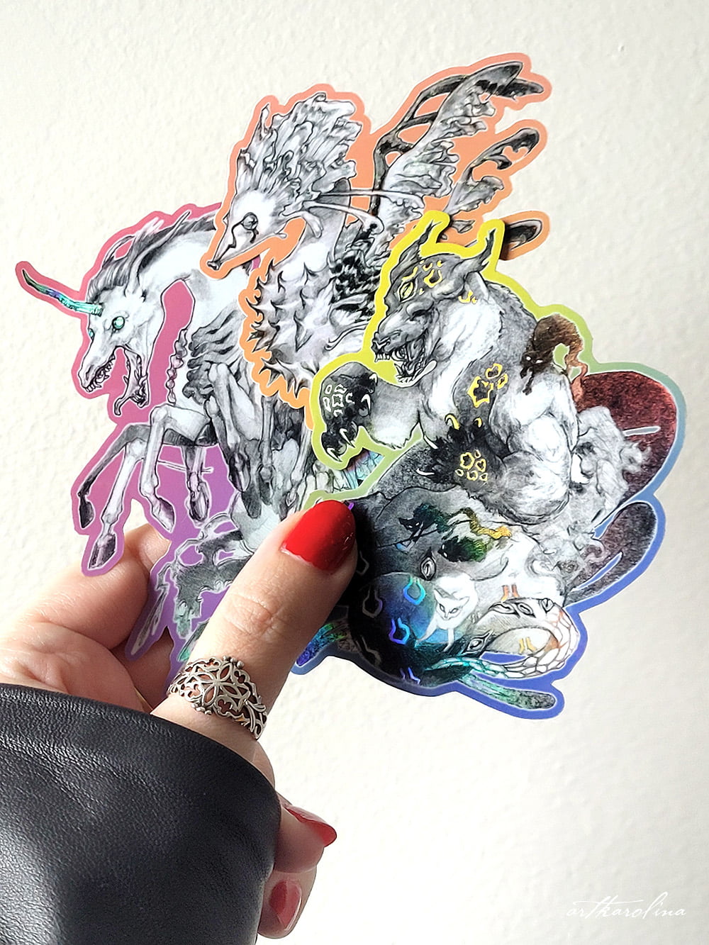 3 holographic monster stickers held up against white wall